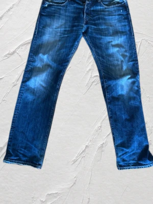 Slevege jeans från replay  - Feta replay jeans med sköna slitningar och snygg fade .  Regular fit| W32 