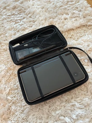 Nintendo DS XL med fodral och laddare - Nintendo DSi XL säljes i fint skick och fungerar som den ska.  Ingår:  Original Nintendo-laddare  2 spel  2 pennor/stylus  Skyddsfodral  Konsolen är väl omhändertagen och perfekt för både samlare och den som vill spela klassiska Nintendo DS-spel. Batteriet håller laddning bra och allt är testat innan försäljning.