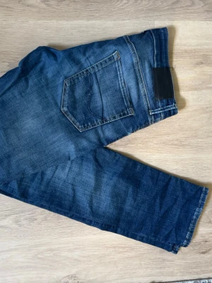 Mörkblå slim jeans från Jack & Jones - Snygga mörkblå jeans från Jack & Jones i modellen Slim Glenn. Jeansen har klassisk femficksdesign, smal passform och är tillverkade i stretchigt denimtyg för extra komfort. Perfekta för en trendig och avslappnad look.