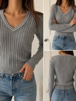 Gant Stretch Cotton Cable V-neck - Snygg grå kabelstickad tröja från GANT med V-ringning och ribbade muddar. Tröjan innehåller Spandex för en bra passform och har detaljer i vitt och ljusrosa runt halsen. Perfekt att matcha med jeans för en avslappnad look.