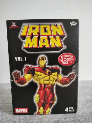 Iron Man Vol. 1 DVD-box Marvel - Iron Man Vol. 1 DVD-box från Marvel med Jetix-logga. Innehåller 4 DVD-skivor med hela 1995 års samling, avsnitt 1-13. Omslaget är svart med en färgstark tecknad Iron Man i rött och gult. Perfekt för fans av superhjältar och tecknade serier.