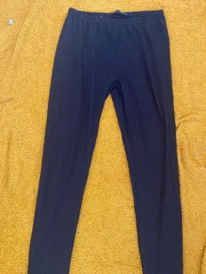 Svarta basic leggings - Ett par svarta leggings med hög midja och smal passform. Perfekta att styla med oversized tröjor eller hoodies. Mjukt och stretchigt material som gör dem bekväma hela dagen.