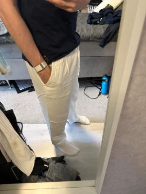 Vita linnebyxor Zara - Snygga vita linnebyxor med avslappnad passform och dragsko i midjan. Byxorna har sidfickor och är tillverkade i ett lätt och luftigt linnematerial, perfekt för varma dagar. Enkla att matcha med t-shirt eller skjorta för en chill look.