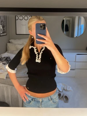 Svart ribbad topp med volangdetaljer - Säljer min oanvända tröja från Lindex. Kom tyvärr inte till andvändning super fint sick. Skriv för frågor eller pris❣️❣️