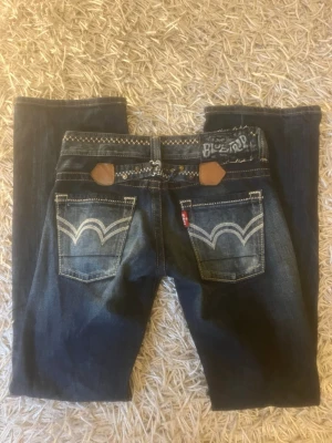 Jeans från EDWIN med snygga sömmar! - Säljer ett par blå jeans från Edwin med coola kontrastsömmar och detaljerade bakfickor. Jeansen har raka ben och slitningar framtill.                Midjemått: 41cm rakt över och passar mig som är 167 samt någon som är något längre i längden.🥰