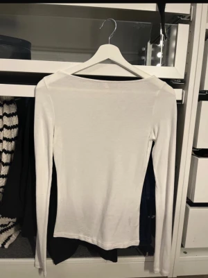 Vit långärmad topp från Nelly - Vit långärmad topp boatneck från Nelly. Aldrig använd 