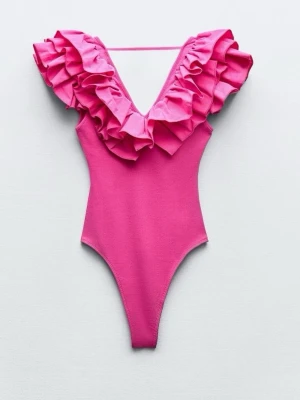 Rosa body med volangdetaljer från Zara  - Supersnygg rosa body med djup V-ringning och stora volanger runt halsen och axlarna. Modellen har högt skurna ben och smal axelrem bak. Tillverkad i stretchigt material som sitter bekvämt och formar sig efter kroppen. Perfekt för dig som vill sticka ut.