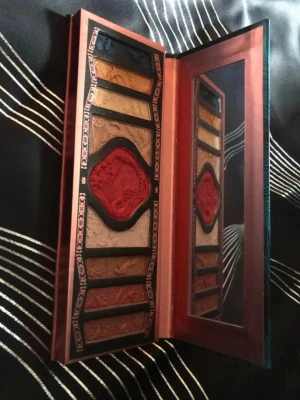 Florasis ögonskuggspalett - Unik ögonskuggspalett från Florasis med vackert mönstrade skuggor i varma toner som guld, brons och rödbrun. Paletten har ett elegant asiatiskt inspirerat yttre i blått och grönt samt en stor spegel på insidan. Perfekt för kreativa sminkningar och detaljerad ögonmakeup.
