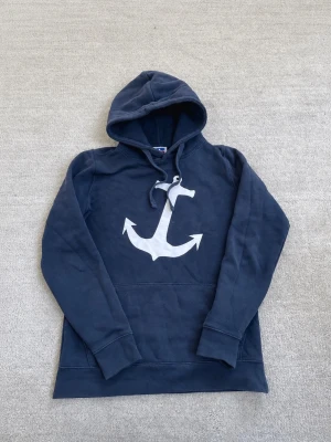 Hoodie - Säljer nu denna feta hoodie i färgen marinblå! Trycket är ett ankare vilket ger en snygg look. Storleken är small (S). Om du har några frågor eller funderingar är det bara att fråga!🤗