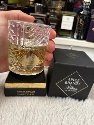 Apple Brandy On The Rocks EdP 50ml - Lyxig parfym från Kilian, Apple Brandy On The Rocks, i en elegant kristalliknande glasflaska med guldfärgad etikett. Doften kommer i en svart och guld ask och flaskan rymmer 50 ml Eau de Parfum. Perfekt för dig som gillar exklusiva och unika dofter. Endast testsprayad! Nypris ca 2100