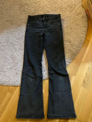 Svarta bootcut jeans från Kappahl - Säljer ett par svarta bootcut jeans från Kappahl i storlek 152. Jeansen har klassisk femficksdesign och är tillverkade i ett mjukt denimtyg. Perfekta för dig som gillar en avslappnad men ändå trendig look. Lite urtvättade men är ändå i dess svarta färg. Kommer tvättas innan de skickas iväg.