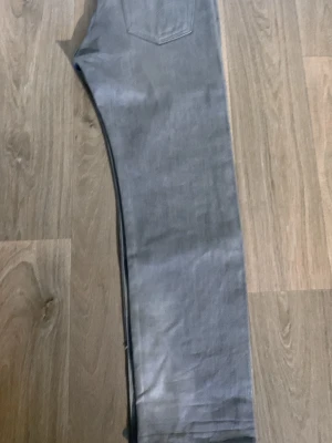 Grå Levis 501 shrink to fit jeans - Snygga grå jeans med rak passform och klassisk femficksdesign. Jeansen har en enkel look utan slitningar eller dekorationer, perfekta för en clean stil. Tillverkade i ett mjukt denimtyg som känns bekvämt hela dagen.