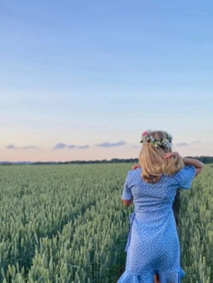 Blå omlottklänning med blommor - Söt blå omlottklänning med vitt blommönster och korta ärmar. Klänningen har volangdetaljer vid ärmsluten och knytband i midjan för en feminin siluett. Perfekt för sommarens alla tillfällen.