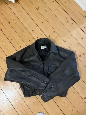 Cropped ”skinn” jacka från NAKD - Croppad jacka i skinn/läder imitation från NAKD, med dragkedja, långa ärmar. Tillkommer en liten päls för kragen som går att ta av. 