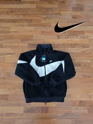 Nike Reversibel Jacka - 🖤 Nike Reversible Sherpa Jacket – Storlek L 🖤 Varm och stilren Nike-jacka med reversibel design som ger två looks i ett. Ena sidan i mjuk sherpa-fleece för värme och komfort, andra sidan i slät sportig Nike-stil för en clean streetwear-look. Full zip, hög krage och loose fit-passfom. Perfekt för höst och vinter eller lager-på-lager outfits. 📦 Snabb leverans – skickas samma dag (om ej hindr.) 📩 Kontakta vid frågor.