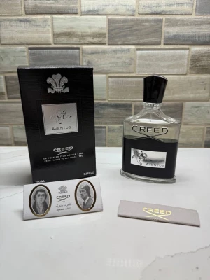 Creed Aventus Eau de Parfum 100ml - Creed Aventus Eau de Parfum i 100 ml flaska. Flaskan är genomskinlig med svart och silver etikett samt svart kork. Förpackningen är svart med silverdetaljer och logotyp. En exklusiv och ikonisk doft som passar dig som vill sticka ut.