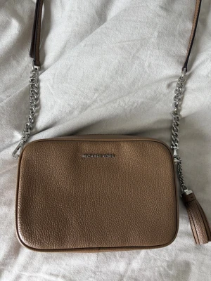 Michael Kors väska  - Brun Michael Kors väska som är använd ca 2 ggr! Modellen heter ”MD camera bag” och är köpt på Nelly för 1500kr 🤍 ge prisförslag! 