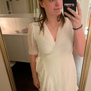 Vit klänning  - Vit omlottklänning från Bubbleroom. Helt ny, aldrig använd med lappen kvar. Tanken var att använda på studenten men då jag hittat en ny klänning och det är för sent att skicka tillbaka säljer jag den nu. Inga fläckar, hel och ren. Nypris: 599