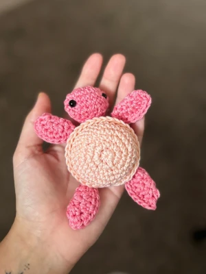 Virkad rosa sköldpadda - Söt handvirkad sköldpadda i rosa och ljusrosa garn. Sköldpaddan har svarta ögon och är gjord av mjukt bomullsgarn. Perfekt som dekoration, present eller leksak. Unik och charmig detalj till rummet eller samlingen.
