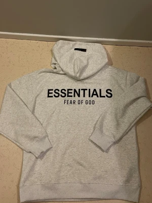Essentials Hoodie - Vit Essentials Fear of God‑hoodie i fint skick. Kommer med originalpåse och taggar.