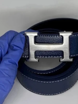 H blått läderbälte med H-spänne - Snyggt blått bälte från H i äkta läder med ett stort, silverfärgat H-spänne i metall. Bältet har vit kontrastsöm längs kanterna som ger en exklusiv känsla. Perfekt accessoar för att lyfta vilken outfit som helst.