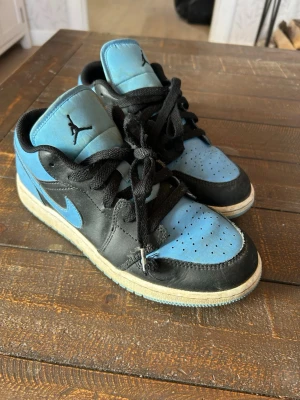 Jordan 1 Low blå och svarta sneakers 38,5 - Snygga Jordan 1 Low sneakers i blått och svart läder storlek 38,5