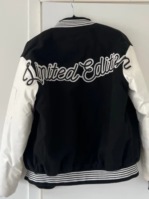 Svart och vit bomberjacka Boohoo Limited Edition - Snygg svart och vit lite tjockare bomberjacka från Boohoo med broderad text 'Limited Edition' på ryggen och detaljer på bröstet och ärmen. Jackan har vita ärmar, svart kropp och randiga muddar. Riktigt cool jacka som är perfekt nu till våren ☺️🥰