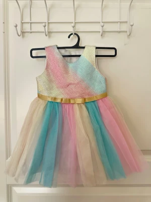 Pastellfärgad glittrig klänning  - Superfin ärmlös klänning i pastellfärger med glittrigt liv och tyllkjol i blått, rosa och beige köpt från Bonnie Baby i USA. Klänningen har en guldfärgad rosett i midjan och är perfekt för dig som vill sticka ut med färg och glitter. 0-18 månader🌸💕