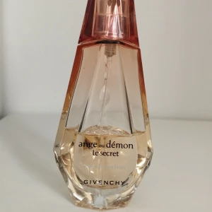 Givenchy Angel of Demon the secret EdP - Givenchy Ange ou Démon Le Secret Eau de Parfum. Parfymen har en feminin och mystisk känsla, perfekt för dig som gillar exklusiva dofter och snygg inredningsdetalj på sminkbordet. Top notes are Tea Leaf, Cranberry, Lemon, Grapefruit and Orange; middle notes are Jasmine Sambac, Peony, Water Lily, Rose and Hedione; base notes are White Musk, White Woods, Patchouli, Vanilla and Amberwood.