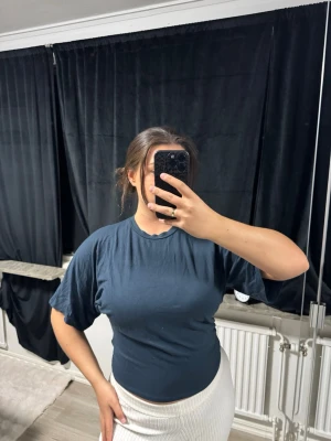 Mörkblå basic t-shirt - En enkel och stilren mörkblå t-shirt med rund hals och korta ärmar. T-shirten har en normal passform och är gjord i mjukt bomullsmaterial, perfekt för en avslappnad look. Passar dig som gillar klassiska plagg med en clean vibe.