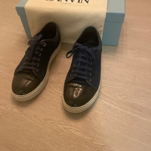 Lanvin - Säljer dessa för jag har växt ur de. Ett par Lanvins i mörkblå färg med glans (den mest betraktade modellen) skorna är extremt snygga och passar alla sorters outfits, inga defekter bortsett från creaset på glansen, passar runt 42-43. OBS bilderna är lite äldre så sulan är det lite mer defekt på☺️🤔Skriv för fler bilder så löser jag det inom kort😇