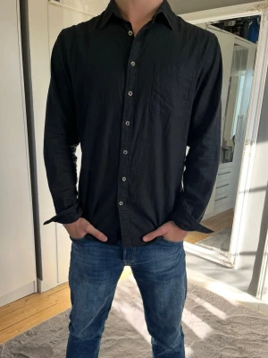 Svart linneskjorta  - Säljer nu min svarta linneskjorta från dressmann då den inte passar. Passar L perfekt! Nypris 699, endast använd 2-3 gånger! Vid funderingar hör gärna av dig!