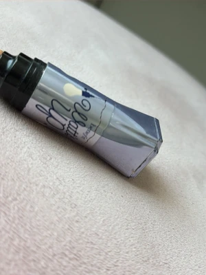 Benefit  highlight  - Den ger en naturlig lyster och har en ljusbeige ton. Förpackningen är silvrig med svart lock och text. Perfekt för att highlighta och täcka mörka ringar under ögonen. Den är använd men säljs pga att den inte har använts på jätte länge.