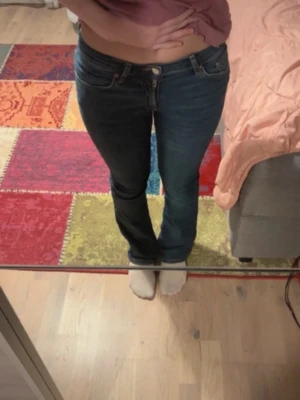Mörkblå bootcut jeans - Säljer ett par mörkblå bootcut jeans med klassisk femficksdesign och låg midja. Jeansen har en snygg tvätt och sitter tight över låren för att sedan bli vidare nedtill. Perfekta till sneakers eller boots!