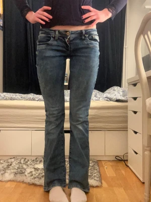Ltb Valerie lågmidjade jeans - Snygga blå bootcut jeans med låg midja och klassiska fem fickor. Jeansen har en lätt tvättad look och sitter tajt över låren för att sedan bli vidare nedtill. Perfekta för en avslappnad och trendig stil. Ltb jeansen har inga defekter och är knappt använda❤️❤️