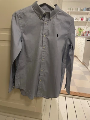 Grå kortärmad skjorta från Ralph Lauren - Ljus blå skjorta från Ralph Lauren i ett suveränt skick, nästan som ny.                                                Storlek S.                                                                                  Perfekt till sommaren. Var inte rädda att diskutera priset          