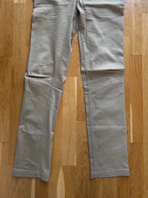 Beiga raka chinos - Snygga beiga chinos med rak passform och klassisk design. 