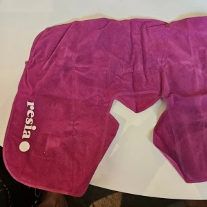 Nackkudde - Säljer en lila resekudde från Resia i mjukt, sammetsliknande material. Den är perfekt för dig som vill resa bekvämt på flyget, tåget eller i bilen utan att ta upp onödig plats i väskan. Varför välja denna kudde? Tar ingen plats: Eftersom den är uppblåsbar tömmer du den enkelt på luft och viker ihop den när den inte används. Justerbar komfort: Du bestämmer själv hur hård eller mjuk du vill ha den genom att reglera mängden luft. Mjuk finish: Det lila tyget är lent mot huden och gör det lätt att sl