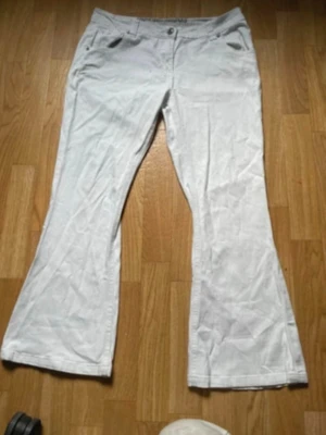 Vita lågmidjade bootcut - Säljer ett par vita bootcut jeans med klassisk femficksdesign. Jeansen har utsvängda ben och låg midja, perfekta för en cool look. Materialet är denim och de har bälteshållor samt knapp- och dragkedjegylf. Säljer för att jag hittat ett nyare par. De har inga fläckar eller defekter☺️ tveka inte att fråga om mått mm.