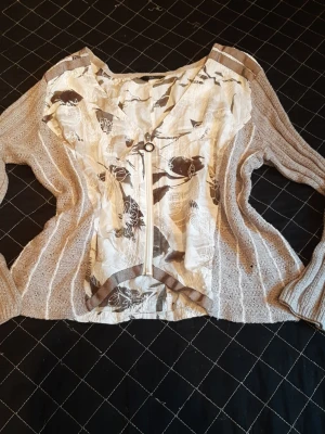 Unik kofta från Kallo - Beautiful cardigan in a colour of beige, brown, grey and white.  Unique shape. Lovely to touch the mixed materials. Zipp at the front. Perfect for spring...  In very good condition. Measurements on pictures.  I think it fit for size M/L.