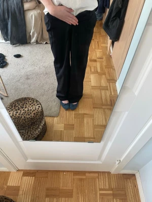 Svarta vida kostymbyxor - Säljer ett par svarta kostymbyxor med rak och vid passform. Byxorna har hög midja och klassisk look, perfekta till en stilren outfit. Materialet ser ut att vara ett mjukt tyg som faller snyggt. Inga synliga detaljer eller mönster. Super fina hör av dig förfrågor❣️❣️💓💓
