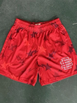 Röda basketshorts med stjärnmönster - Snygga röda basketshorts med mörkröda och svarta stjärnor över hela tyget. Resår i midjan och vit logga på vänster ben. Perfekta för träning eller chill. Lätta och luftiga i materialet.