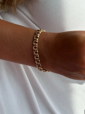 Mulicollection - Bismarck Bracelet från Muli Collection Tillverkat i 925 silver/vattentåligt 18k guld PVD pläterat stål. Designen bygger på den klassiska Bismarck-länken, med tätt sammanlänkade delar. Med en tunn bredd på 0,6 mm får armbandet ett diskret men synligt utseende. Det kan bäras för sig själv eller kombineras med andra armband för en mer personlig stil.