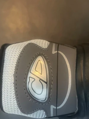 B30 - Snygga sneakers från CD Shoes i grått och svart med reflekterande detaljer och tydlig DC-logga på sidan. Ovandelen är i mesh och syntetmaterial för bra andningsförmåga och komfort. Skorna har en chunky svart sula och klassisk snörning.