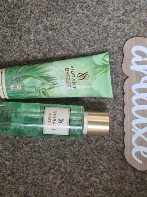 Vibrant Breeze body mist & lotion set - Fräscht set med body mist och body lotion från Victoria's Secret i doften Vibrant Breeze. Båda produkterna har gröna förpackningar med tropiskt bladmotiv och guldiga detaljer. Doften har inslag av kokosnöt, sandelträ och havsbris för en exotisk känsla. Helt nya och oanvända