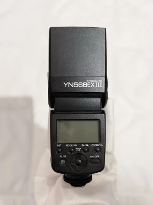  Yongnuo YN568EX III TTL blixt för Canon/Nikon DSLR-kameror - Yongnuo YN568EX III TTL blixt för Canon/Nikon DSLR-kameror. Blixten har TTL- och High Speed ​​Sync (HSS)-funktioner. I priset ingår:   - Blixt - Panasonic Eneloop BQ-CC55 laddare (behöver en adapter eftersom den är lämplig för Australiens eluttag) - väska. 
