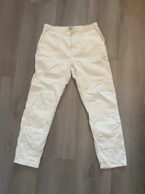 Vita linnebyxor från Morris - Snygga vita linnebyxor med raka ben och hög midja. Byxorna har dragkedja och knapp framtill samt sidofickor och två bakfickor med knapp. Perfekta för en avslappnad och stilren look. Materialet är tunt och luftigt linne.