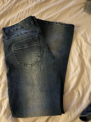 Mörkblå jeans med tvättad look - Säljer dessa jätte fina jeans från Gina 14+ i storlek m. De är låga i midjan och har ett stretchigt material. Använd fåtal gånger och är i ett bra skick. 