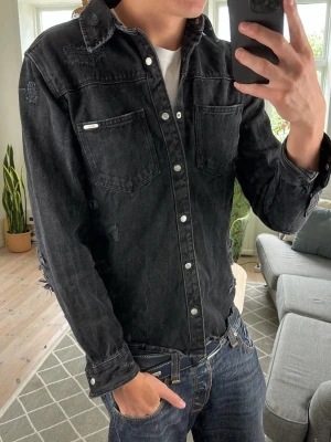 Jeansskjorta svart  - Trendig och väldigt stilren perfekt till alla outfits! Mått: A:45 B:44 C:46 D:62 (cm) 
