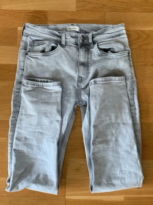 Ljusblå jeans från GANT - Säljer ett par ljusgråa jeans från GANT. Jeansen har en snygg tvättad look. Perfekta för dig som gillar en avslappnad men stilren vibe. Jeansen är 158cm men passar några centimeter till.